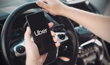 Uber logo displayed on smartphone screen, representing Uber delivery fee class action lawsuit.