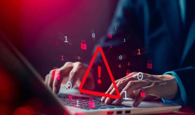 Close up of a man typing on a laptop with a data warning concept symbol overlay, representing the Evolve Bank data breach.