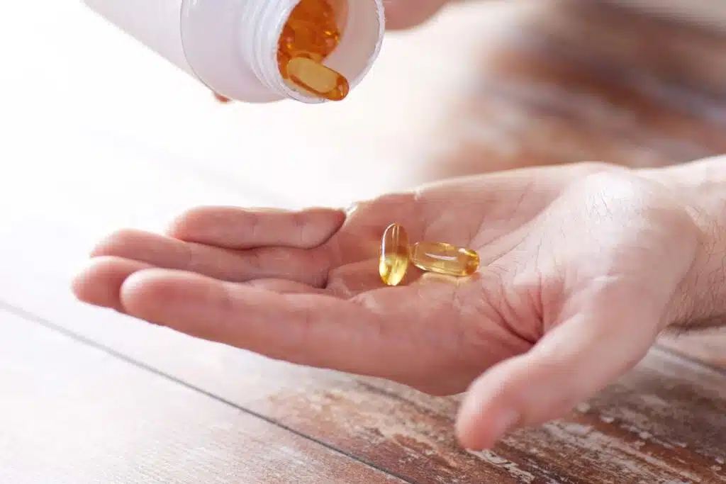 Close up of fish oil softgels being poured into a hand, representing the fish oil supplements class action.