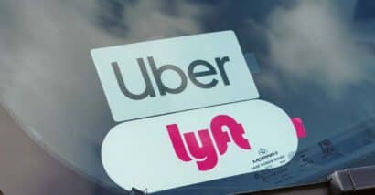 Close up of Uber and Lyft sticker in a car window, representing the Uber and Lyft settlement.
