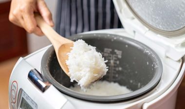 Close up of white rice being scooped out of a rice cooker, representing the Sunbeam class action.