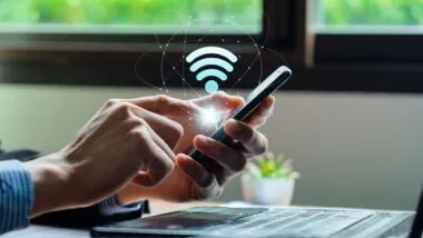 Close up of a man using a phone with a wifi symbol overlay, representing the Metronet class action.