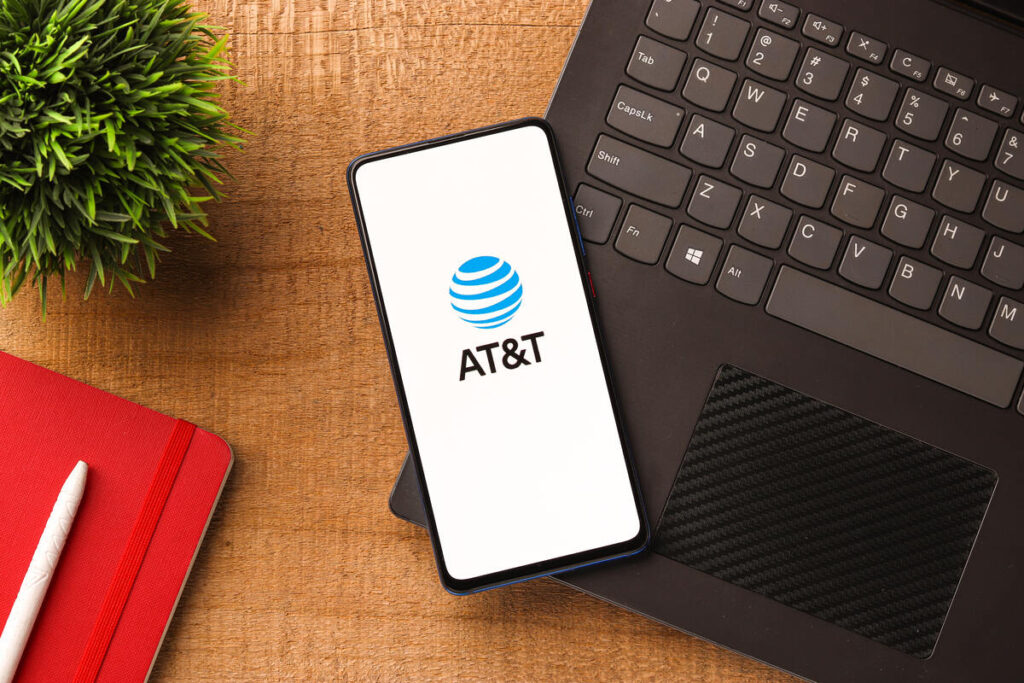 At&t logo on cell phone laying on a computer representing the AT&T data breach.