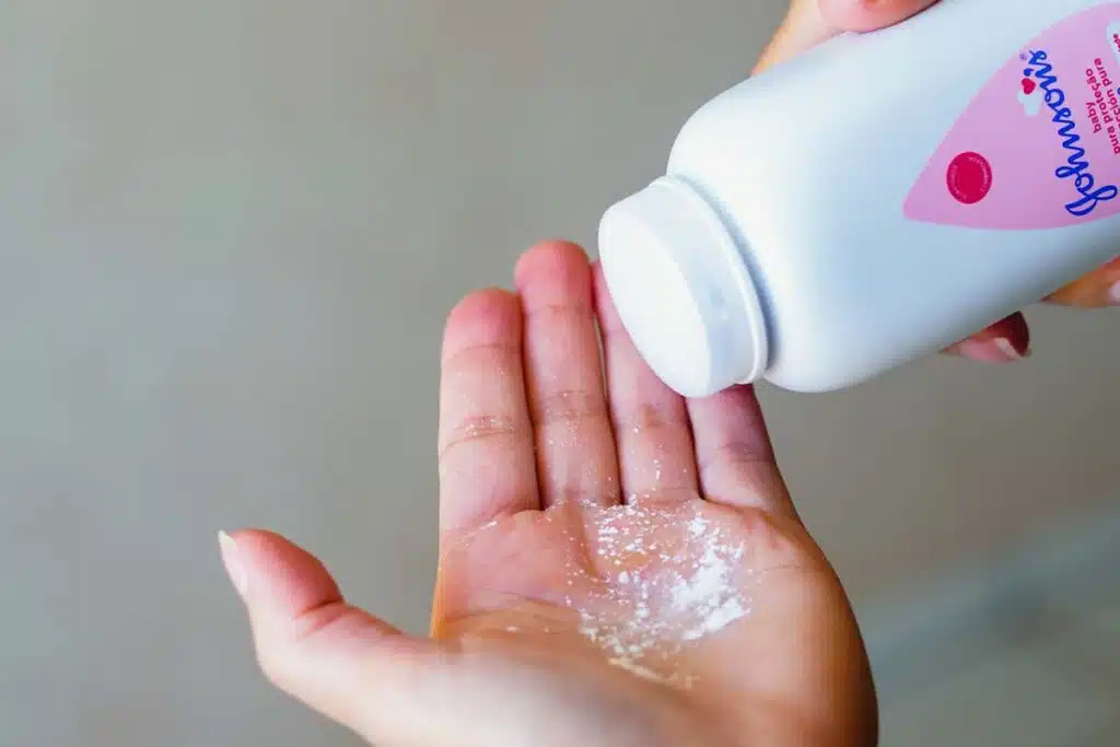 Close up of a woman pouring Johnson & Johnson powder into her hand, representing the J&J talc verdict.