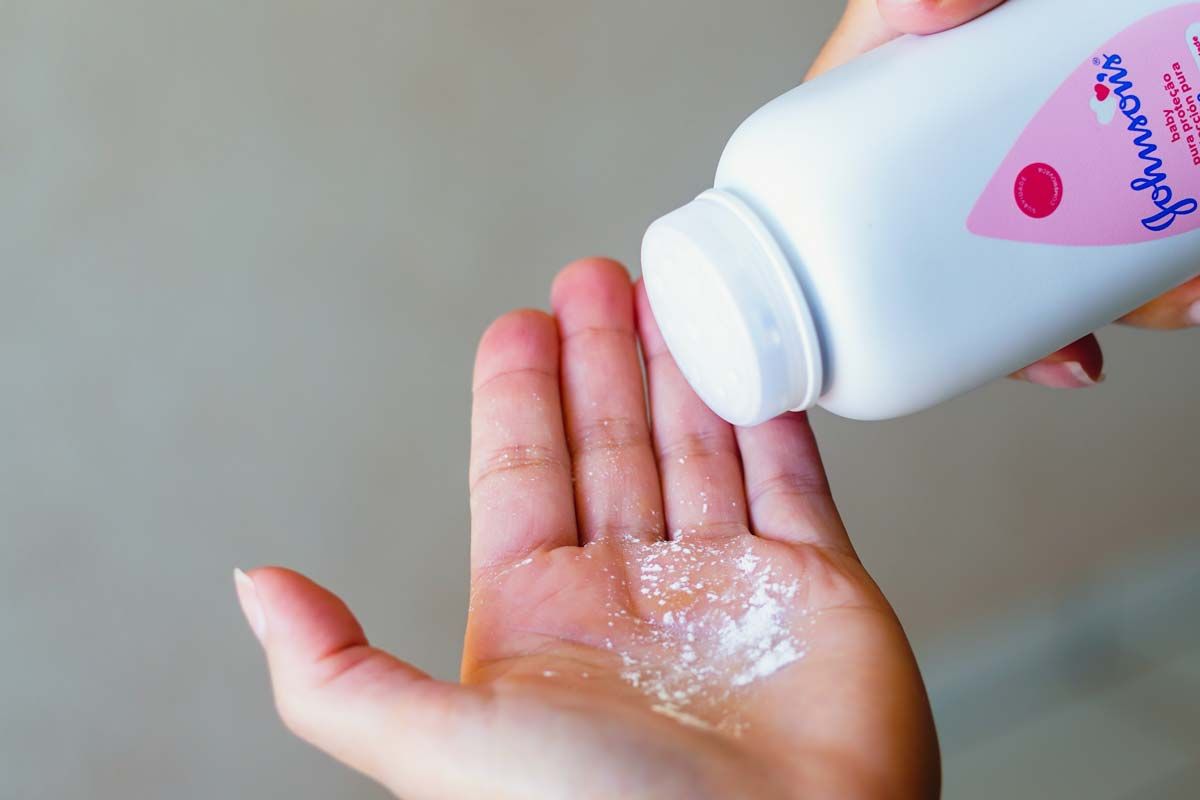 Close up of a woman pouring Johnson & Johnson powder into her hand, representing the J&J talc verdict.