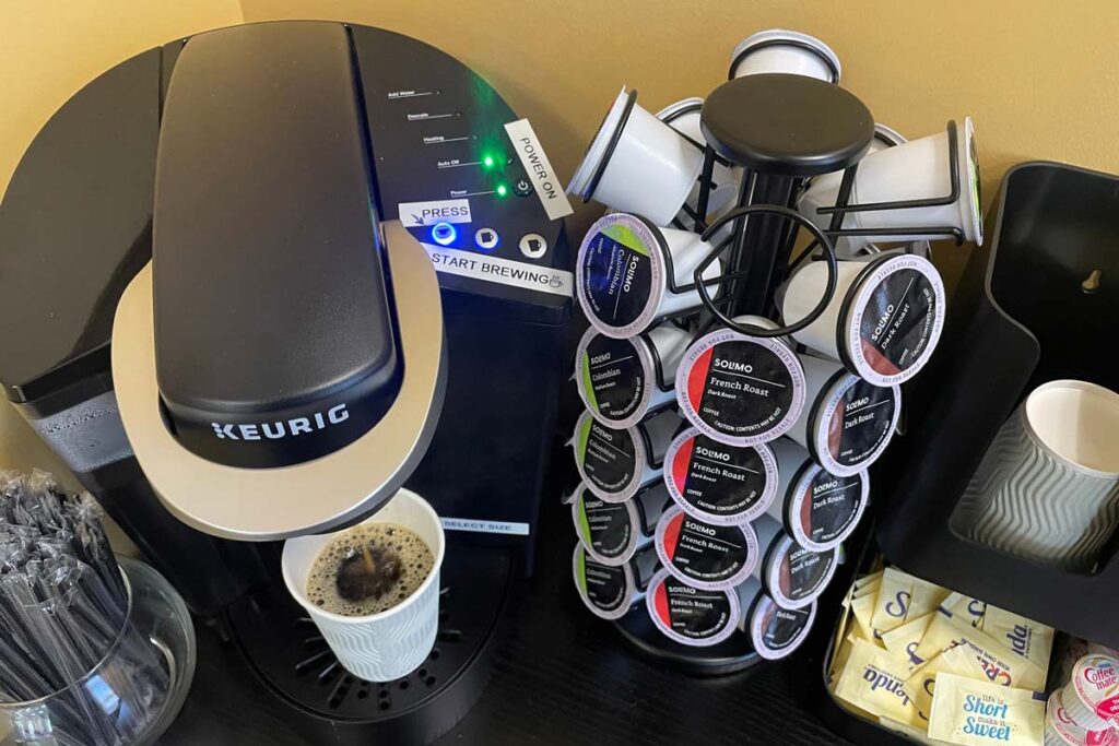 Keurig k-cups next to a Keurig coffee maker, representing the Keurig fine.