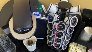 Keurig k-cups next to a Keurig coffee maker, representing the Keurig fine.