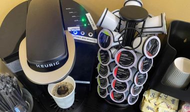 Keurig k-cups next to a Keurig coffee maker, representing the Keurig fine.