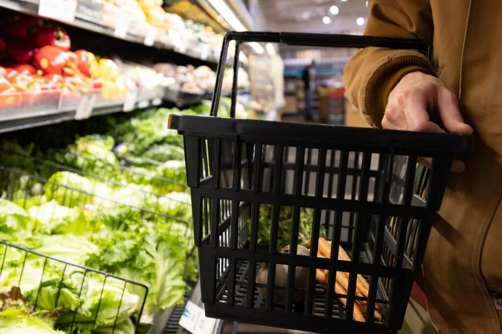 Man walking in a grocery store holding a basket representing top recalls for the week of Sept. 23.