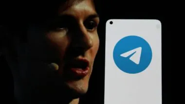 CEO of Telegram next to a Telegram logo on a cell phone representing the Telegram CEO indictment.