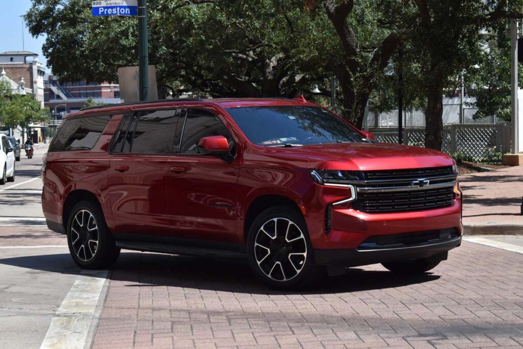 A red metallic Chevrolet Tahoe driving along a road, representing the GM recall.