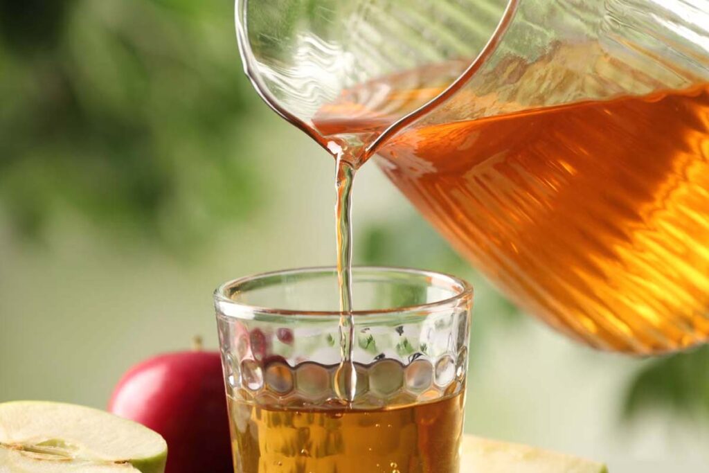 Close up of apple juice being poured into a cup, representing beverage class actions.