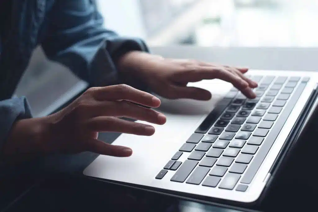 Close up of a hands typing on a laptop, representing the AXS class action.