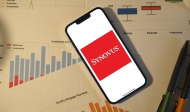 Synovus Bank logo on a cell phone on top of spreadsheets representing the Snyovus Bank class action.