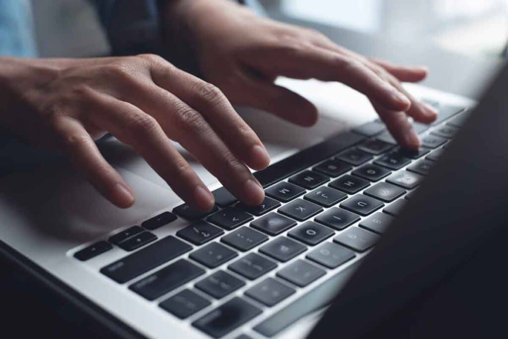 Close up of hands typing on a laptop, representing the Internet Archive data breach.