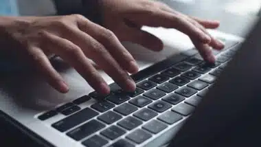 Close up of hands typing on a laptop, representing the Internet Archive data breach.