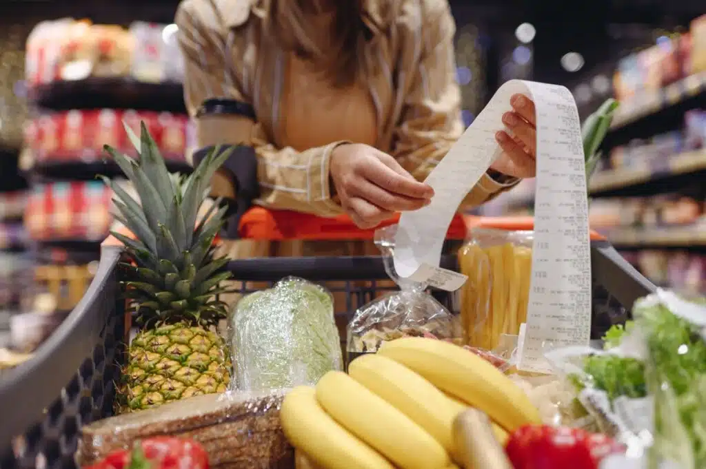 Woman checking her grocery store receipt representing top recalls for the week of Oct. 14.