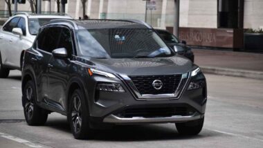 A Nissan Rogue driving along a road, representing the Nissan recall.