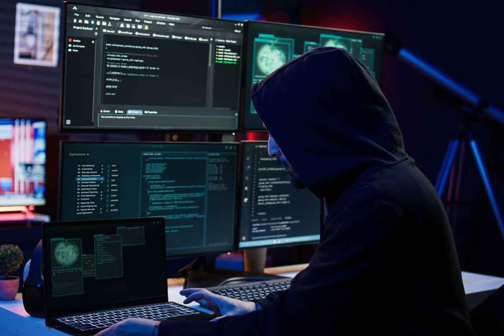 A hooded hacker using a computer, representing the Behavioral Health Group settlement.