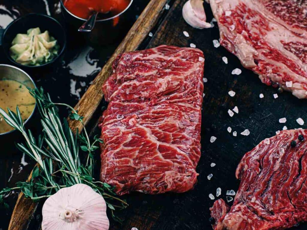 Raw steak laying next to herbs representing the BrucePac class action.