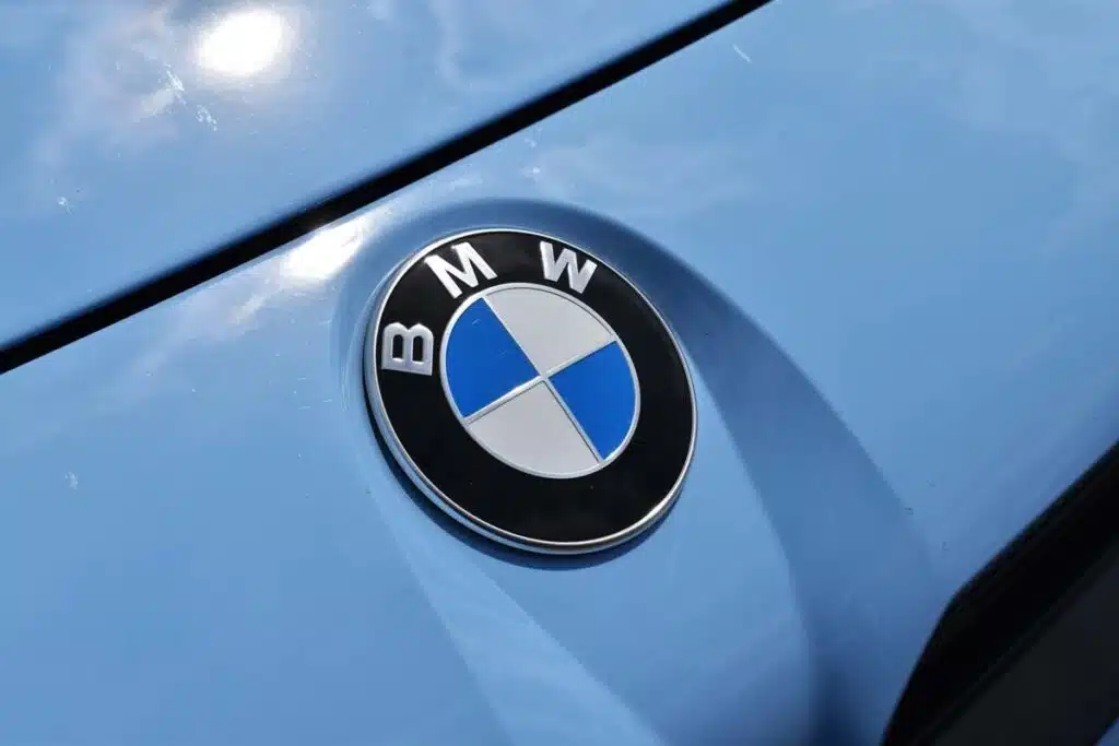 Close up of a BMW emblem on a front bumper, representing the BMW class action.