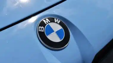 Close up of a BMW emblem on a front bumper, representing the BMW class action.