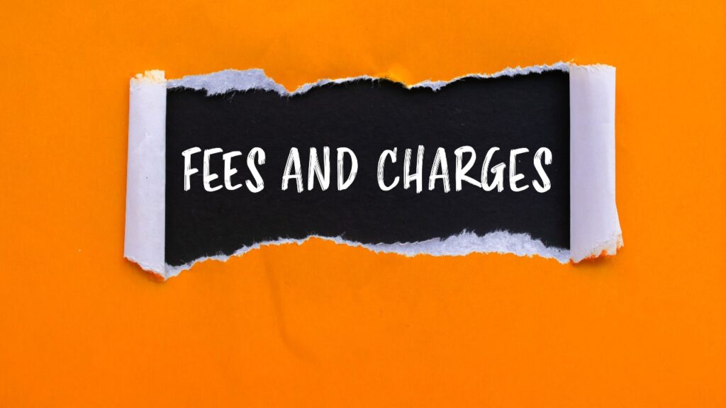 Fees and charges message written on ripped torn orange paper with black background.