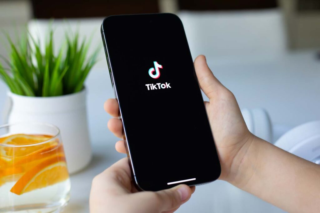 Close up of a childs hands holding a smartphone with the TikTok logo displayed, representing the TikTok lawsuit.