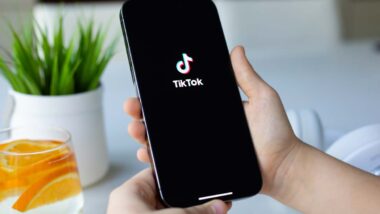 Close up of a childs hands holding a smartphone with the TikTok logo displayed, representing the TikTok lawsuit.