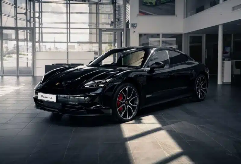 A black Porsche Taycan in a showroom, representing the Porsche recall.