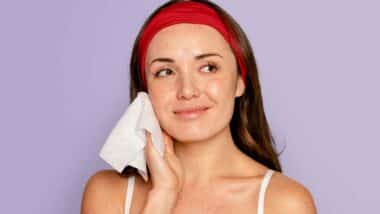 Close up of a woman using a make up removing wipe, representing the Aveeno class action.