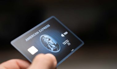 Close up of a hand holding an AmEx credit card, representing the AmEx class action.