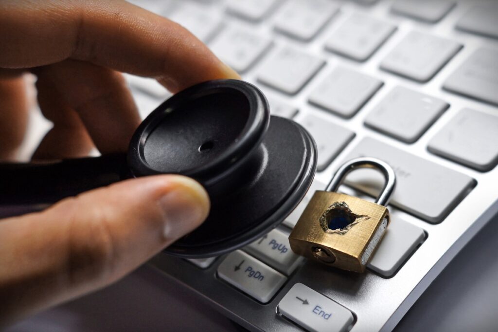 A stethoscope on a computer next to a broken lock representing the Gryphon Healthcare class actions.