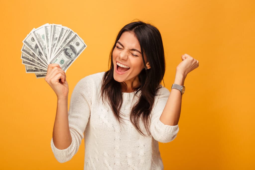 Girl holding cash with a yellow background representing recent settlement checks in the mail.