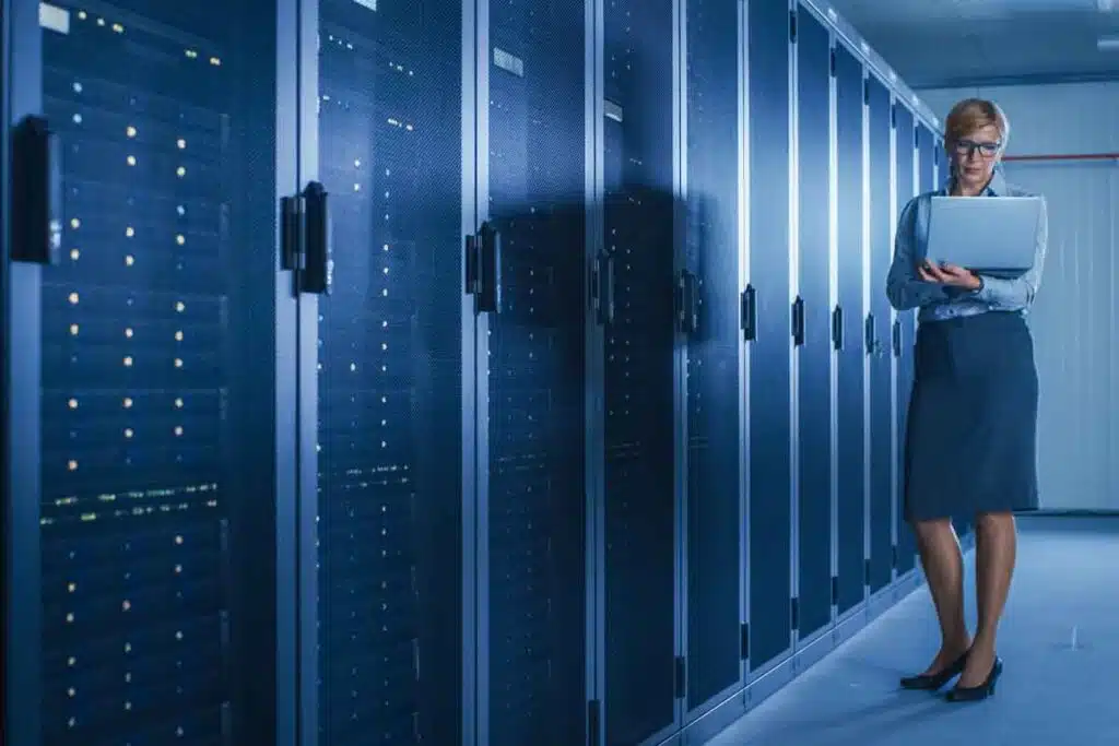 A female IT worker working in a server room, representing the Hilb Group settlement.