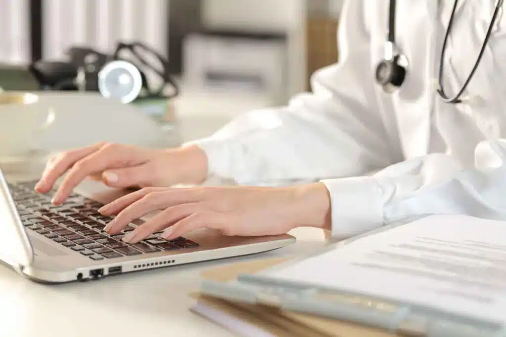 Close up of a doctor typing on a laptop, representing the Pacific Cataract & Laser Institute settlement.