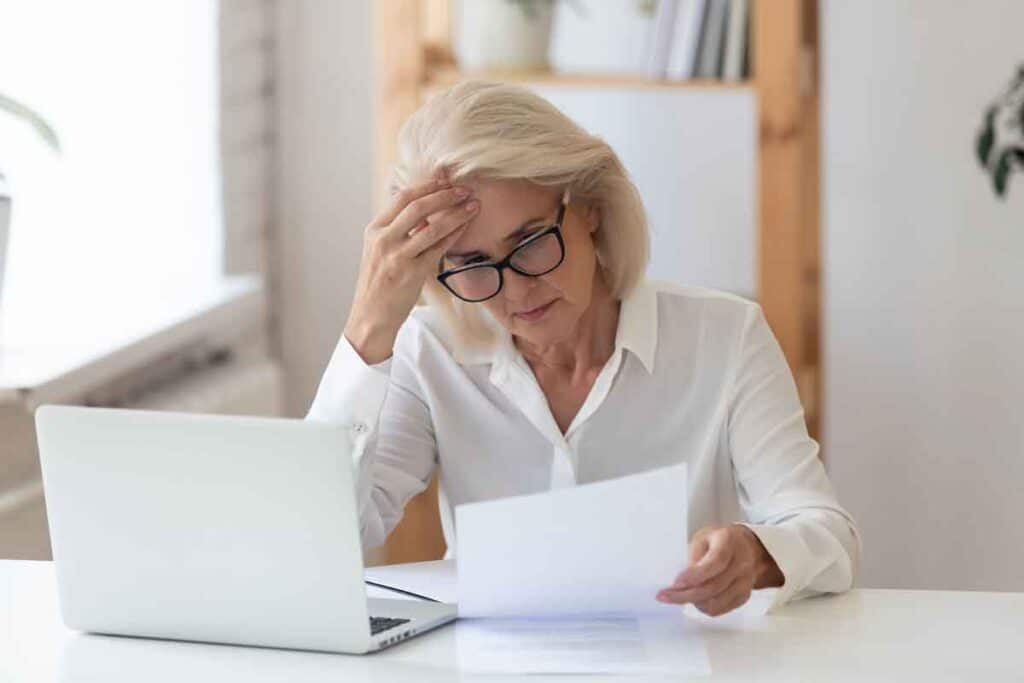 A concerned woman reading a letter, representing the Comenity Bank class action.