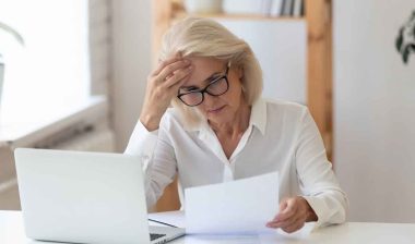 A concerned woman reading a letter, representing the Comenity Bank class action.