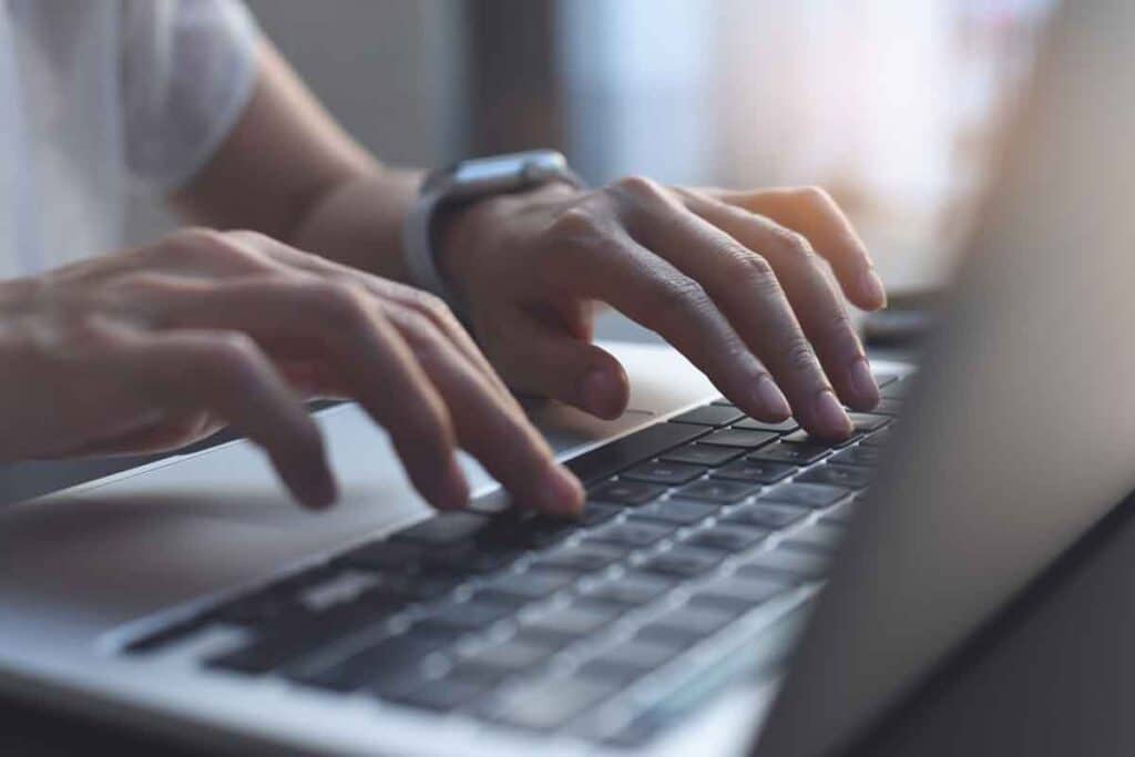 Close up of hands typing on a laptop, representing the Olympic Club settlement.
