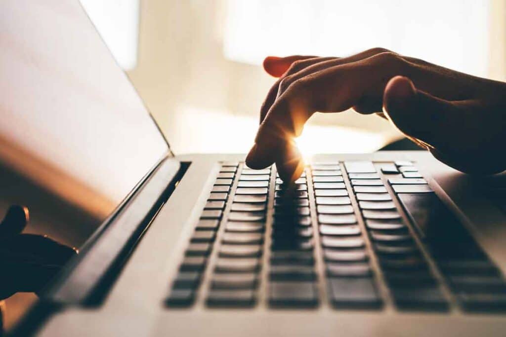 Close up of hands typing on a laptop, representing the Hilb Group settlement.