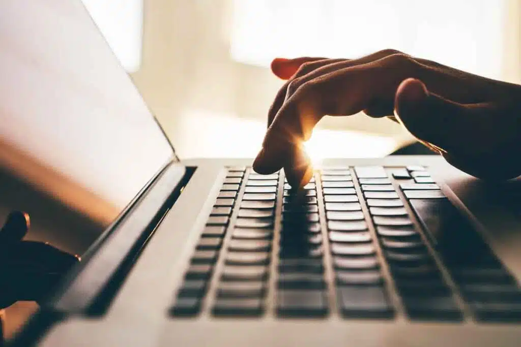 Close up of hands typing on a laptop, representing the Hilb Group settlement.