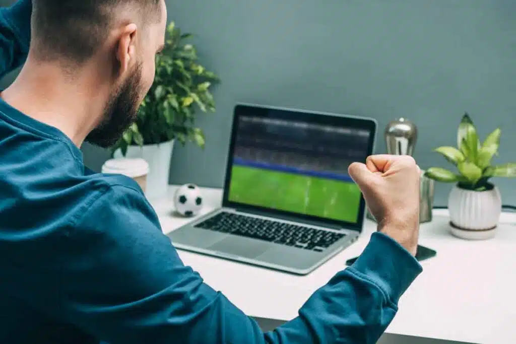A guy watching sports on a laptop, representing the BallerTV.com settlement.