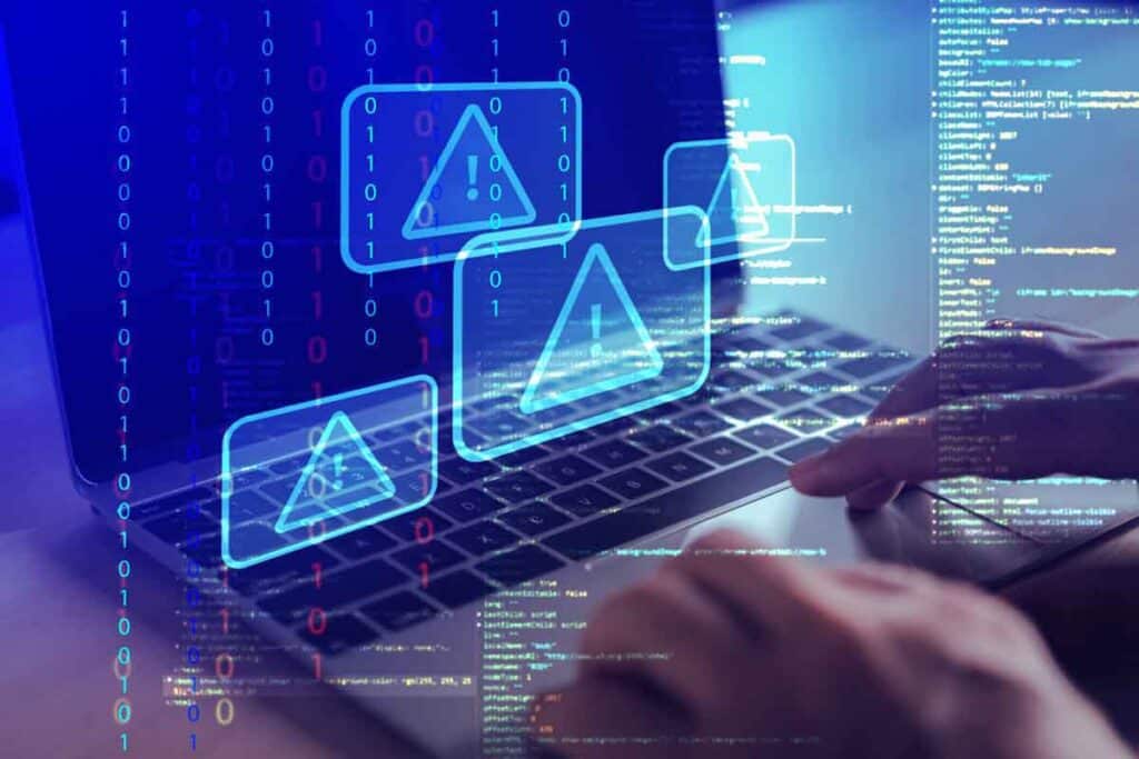 Close up of hands typing on a laptop with a warning symbol overlay, representing the Air Methods settlement.