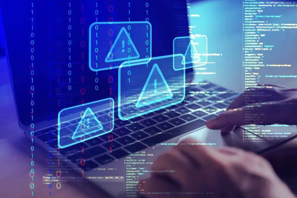 Close up of hands typing on a laptop with a warning symbol overlay, representing the Air Methods settlement.