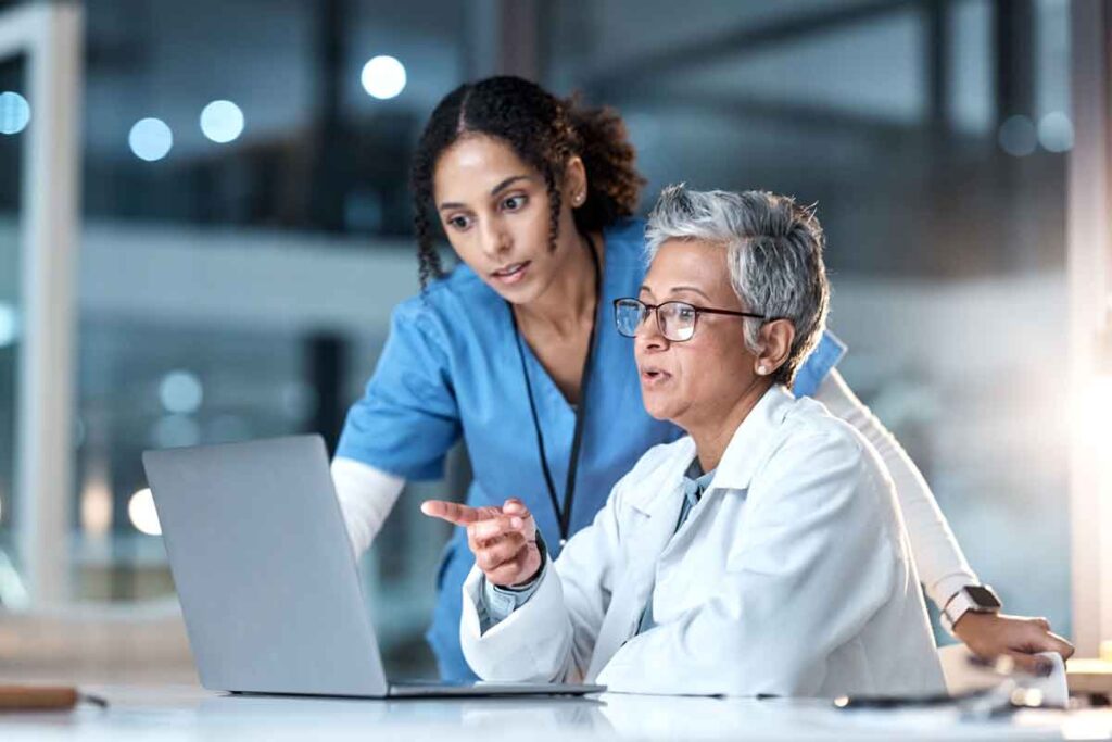 A doctor and nurse using a computer, representing the Oak Valley settlement.