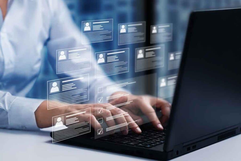 Close up of hands typing on a laptop with a background check concept overlay, representing the Employment Background Investigations settlement.