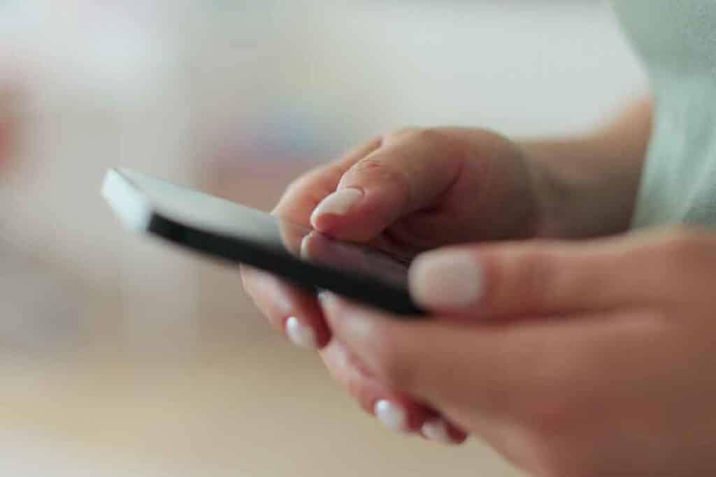 Close up of hands using a smartphone, representing the DaVita settlement.