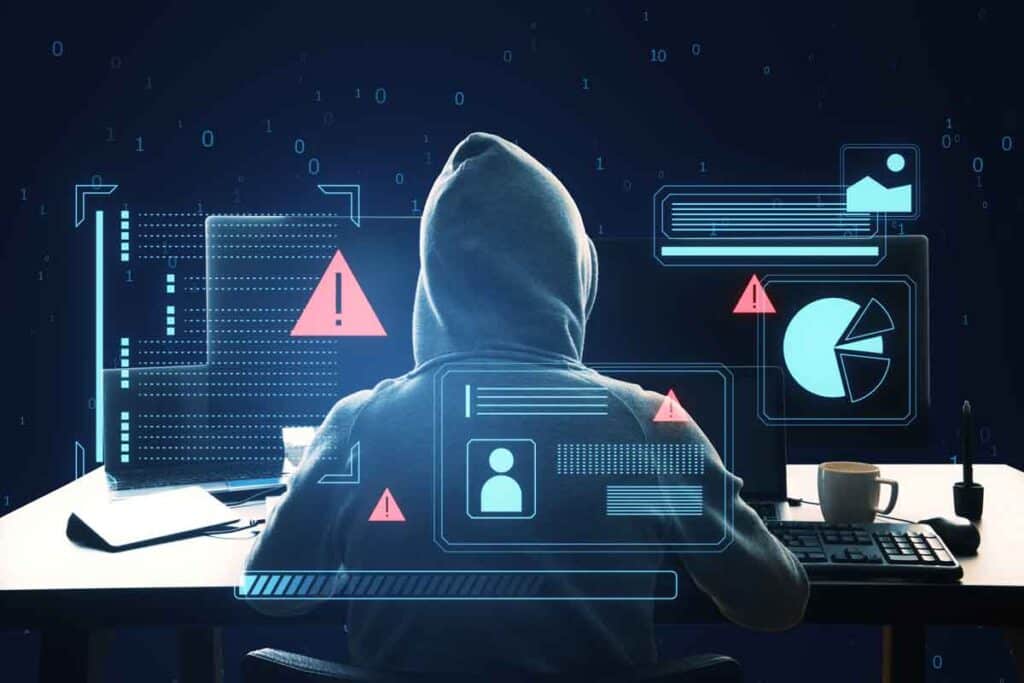 A hooded hacker using a computer, representing the Bridgeway Center settlement.