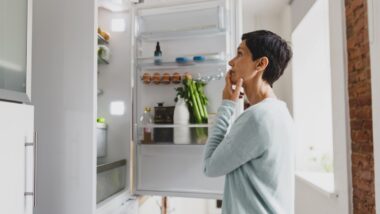Woman looks inside an LG refrigerator representing the LG class action.