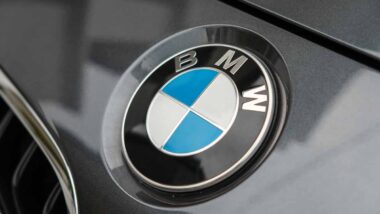 Close up of a BMW emblem on a front bumper, representing the BMW class action.